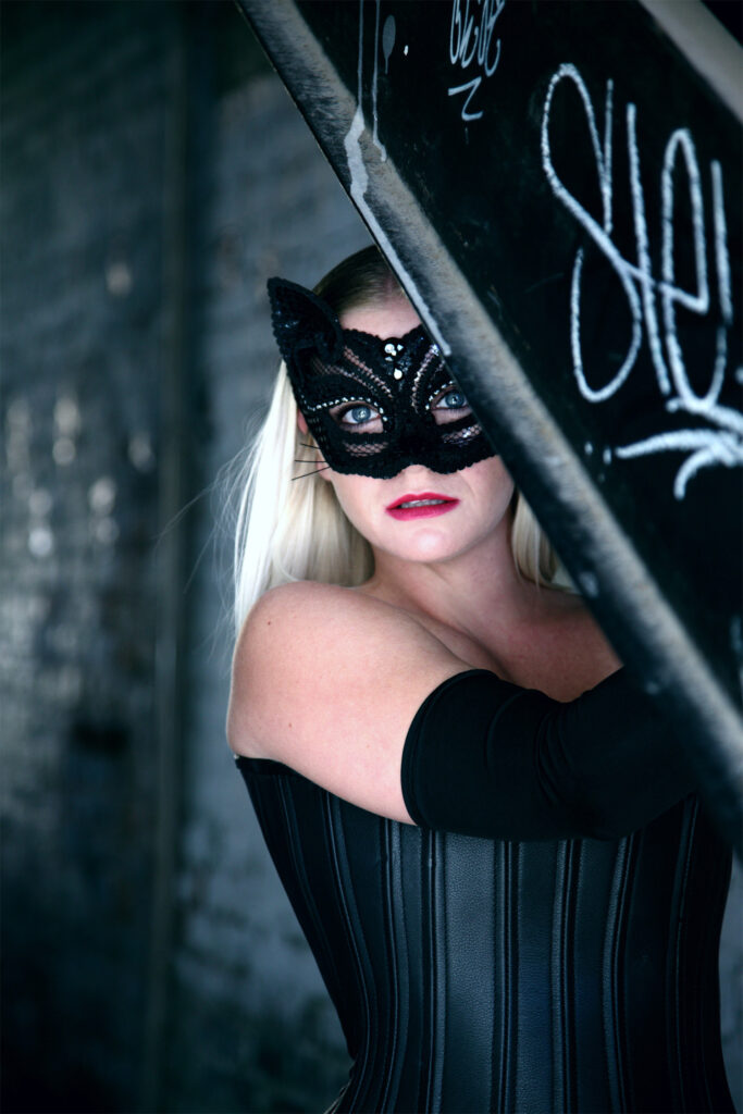 Platinum-haired women wearing black, sexy Halloween lingerie and a cat mask
